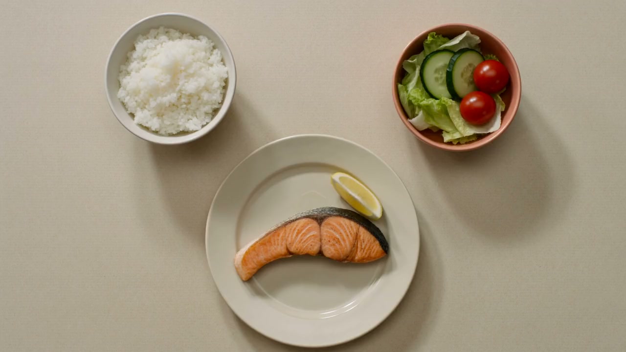 Rice, salmon and salad shown as three separate dishes on a table